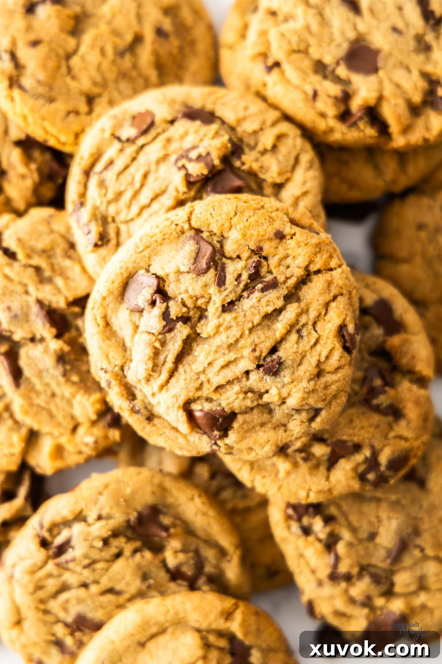 Top down view of a pile of ultimate chocolate chip cookies, freshly baked and golden.