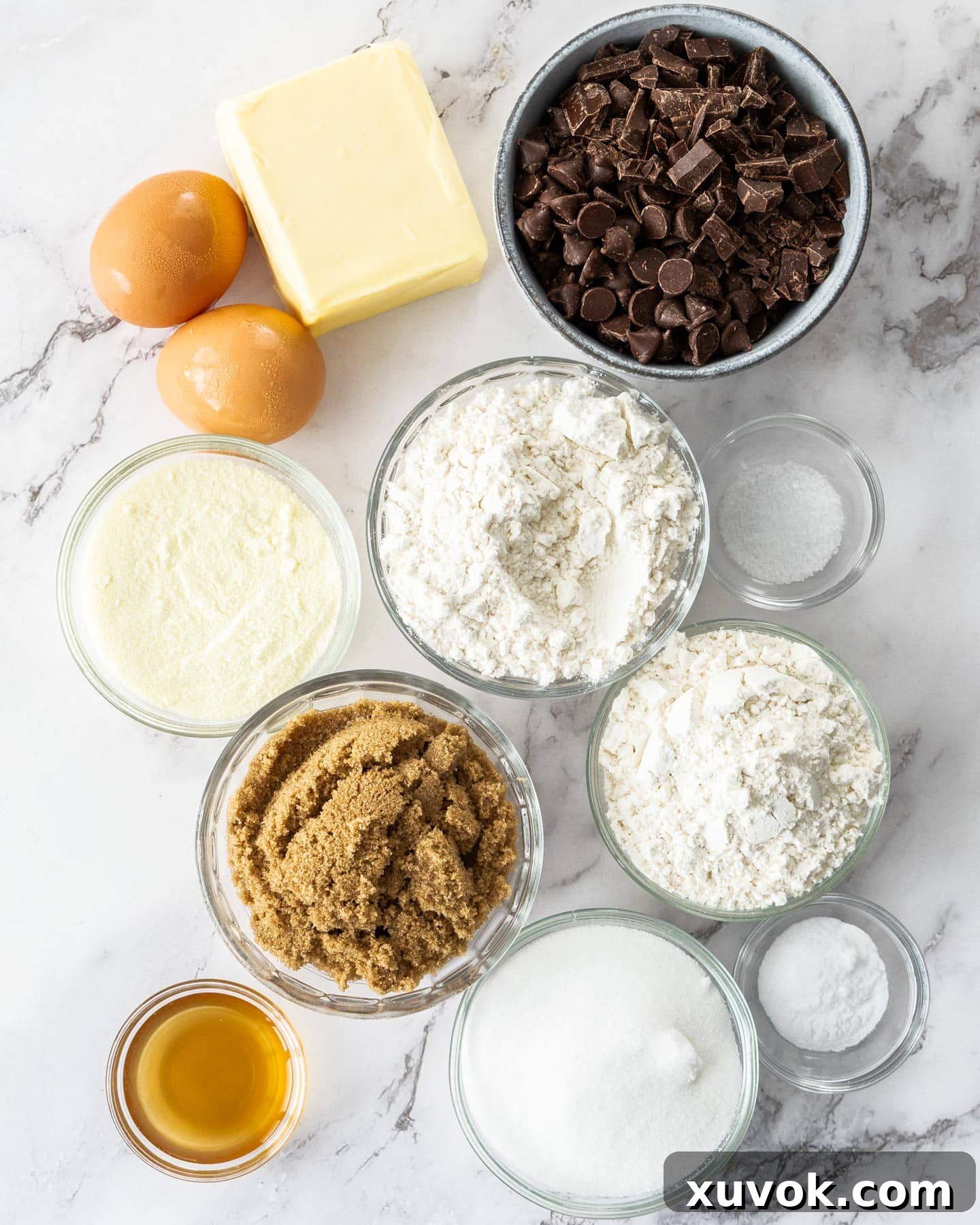 Carefully arranged ingredients for the ultimate chocolate chip cookies on a pristine marble surface.