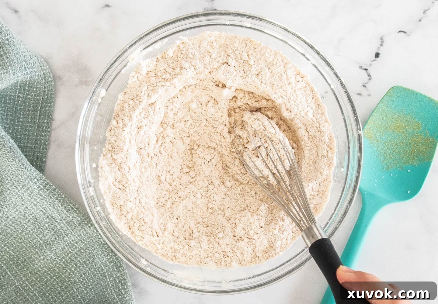 A bowl of meticulously combined dry ingredients, including toasted milk powder and flours.