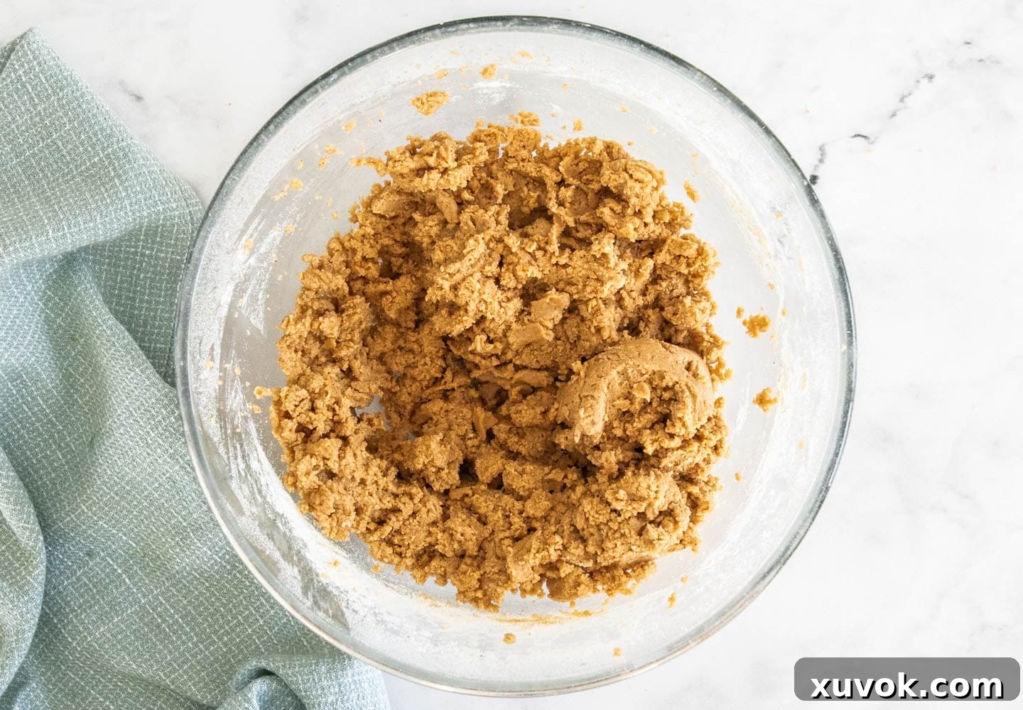 Chocolate chip cookie dough in a bowl, awaiting the addition of chocolate chips, showing a smooth, cohesive texture.