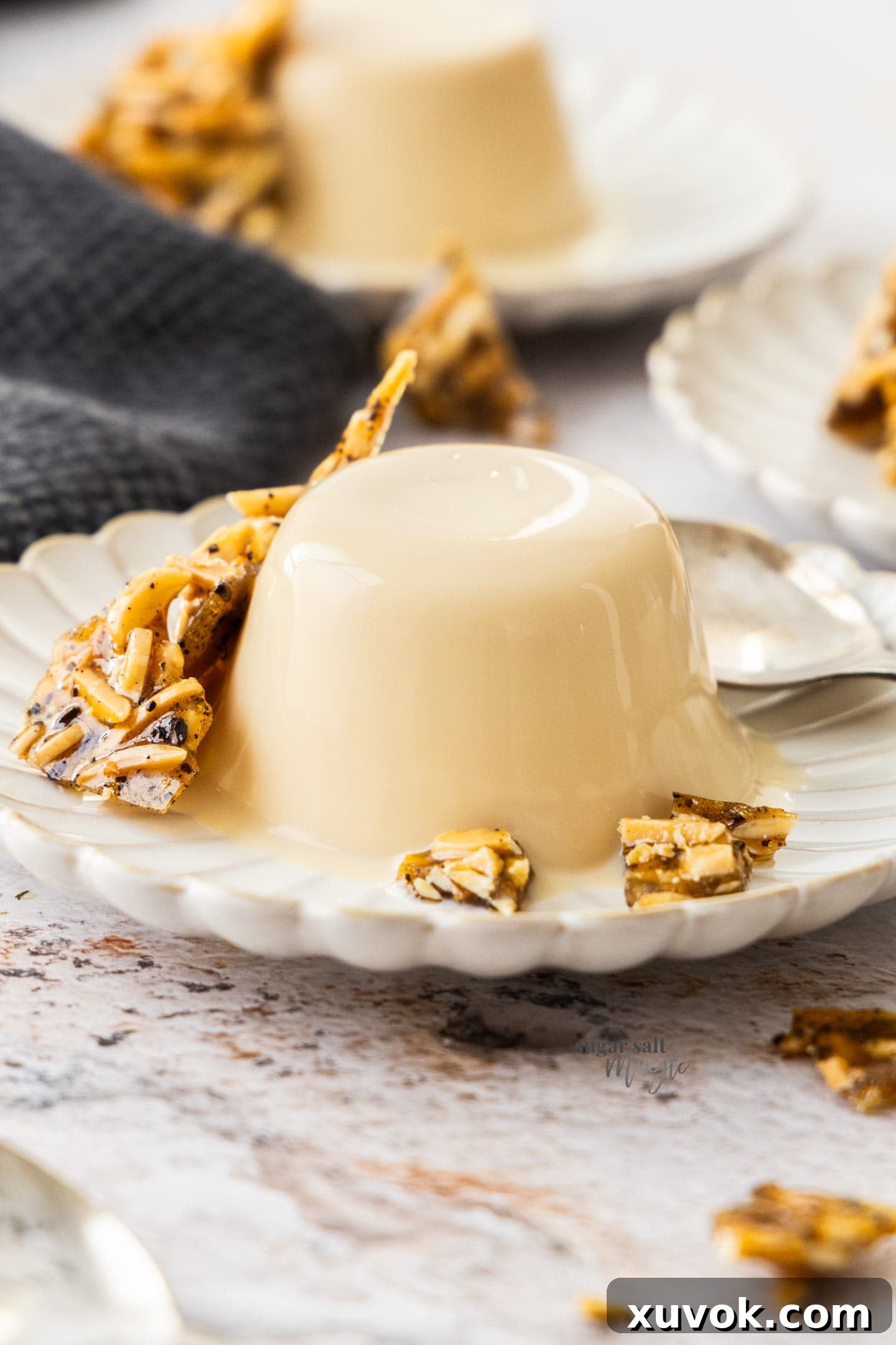Closeup of a Baileys panna cotta on a dessert plate with praline.