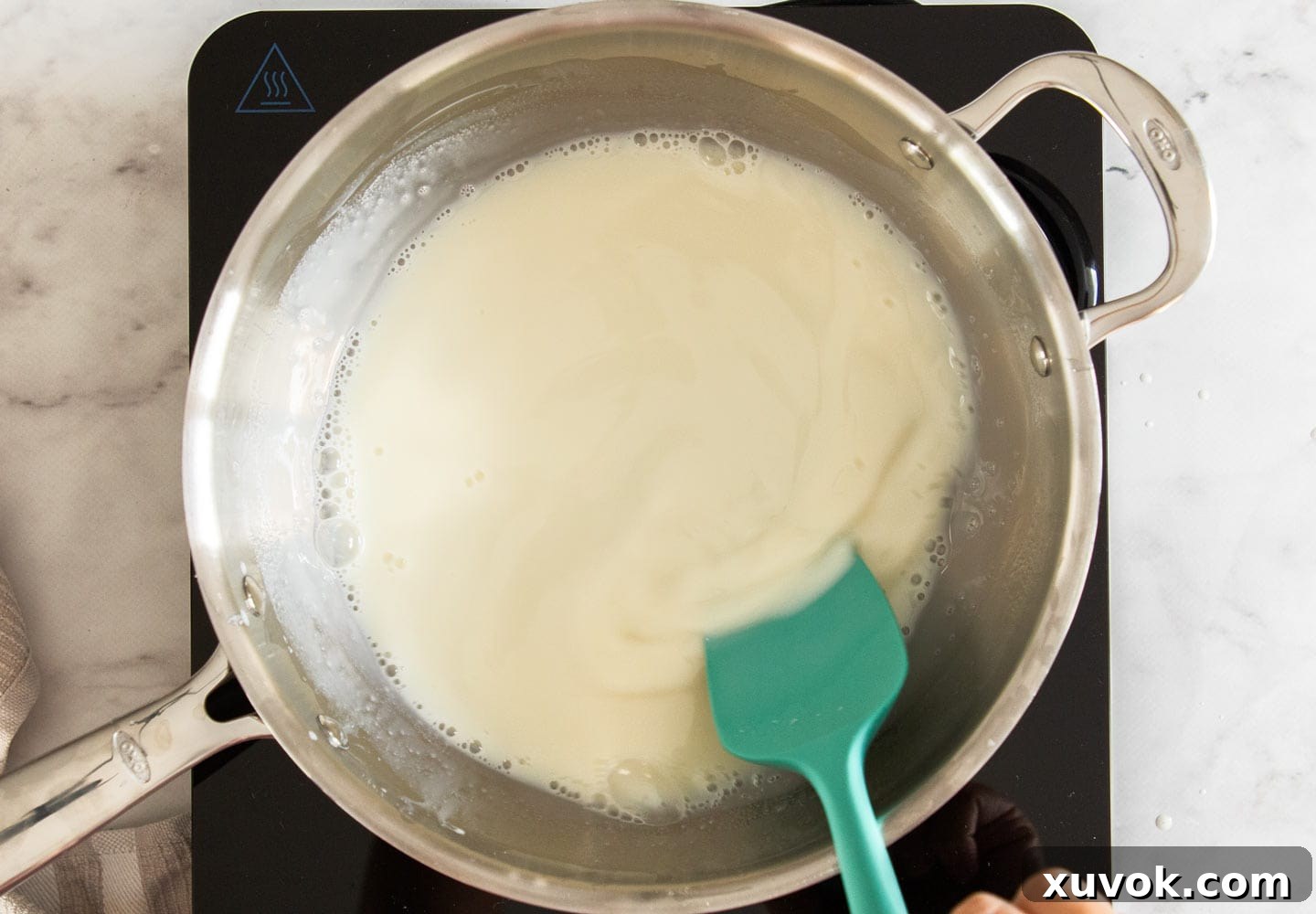 Stirring the sugar into the milk.