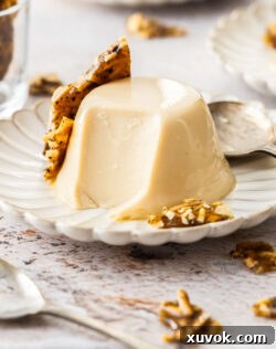 A Baileys panna cotta on a dessert plate with a scoop taken out of it.