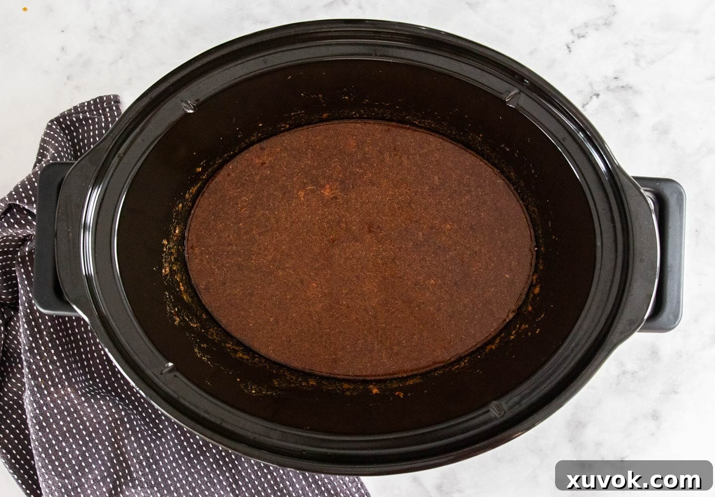 The sauce for the satay chicken in a slow cooker bowl.