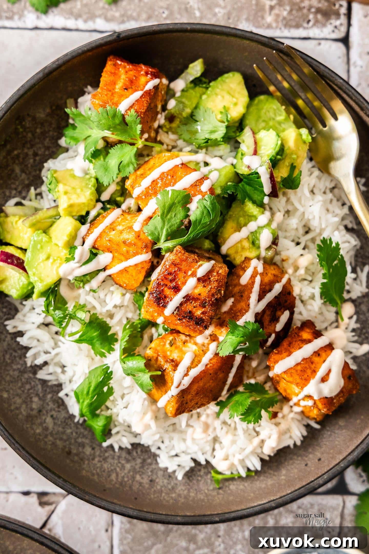 Top down view of a bowl of rice topped with crispy salmon bites.