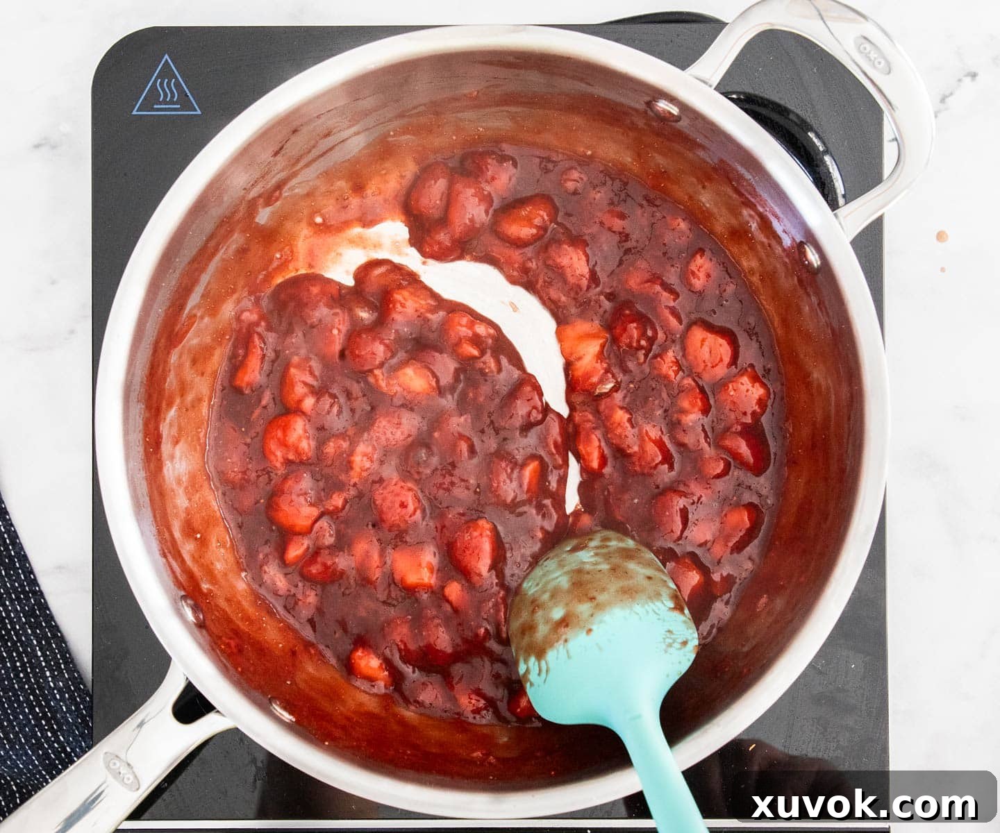 A bowl filled with thick, glossy, and vibrant red strawberry filling, perfectly cooked and ready to be chilled before use in the turnovers.