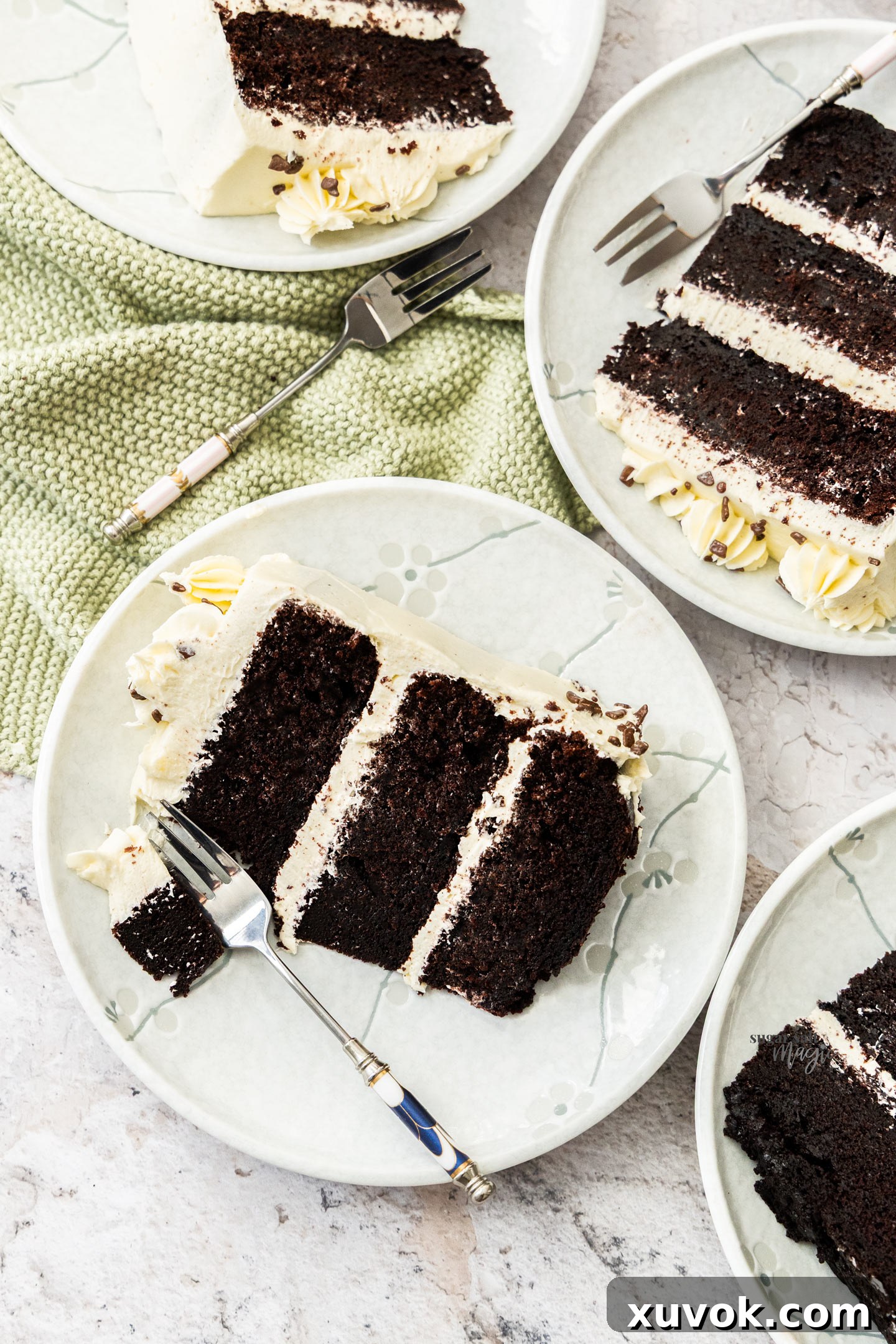 A top-down view of two slices of chocolate and vanilla cake, beautifully presented on dessert plates.