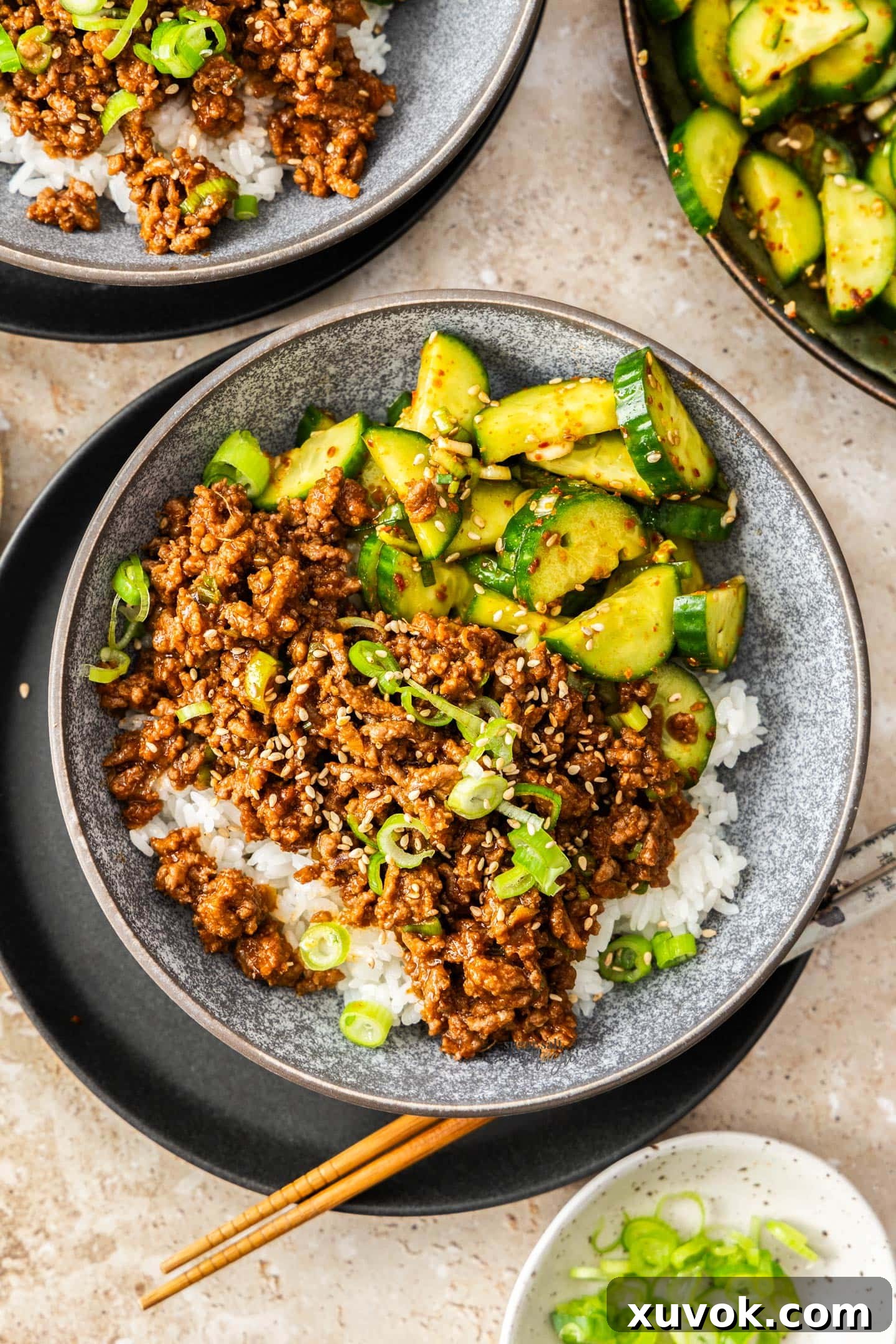 Top down view of a bowl filled with rice, gochujang beef and cucumber salad.