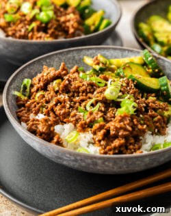 Closeup of a bowl of gochujang beef with cucumber on the side.