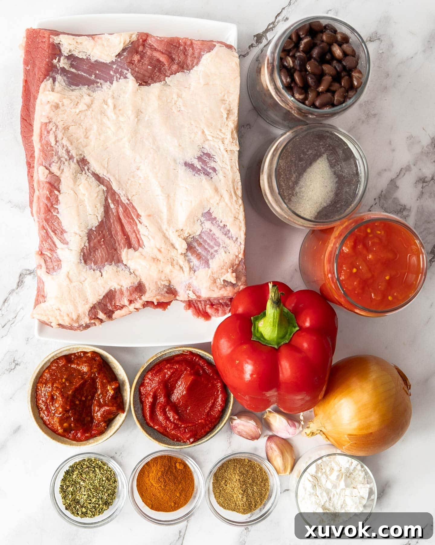 A selection of fresh ingredients and canned goods laid out for slow cooker chilli con carne preparation.