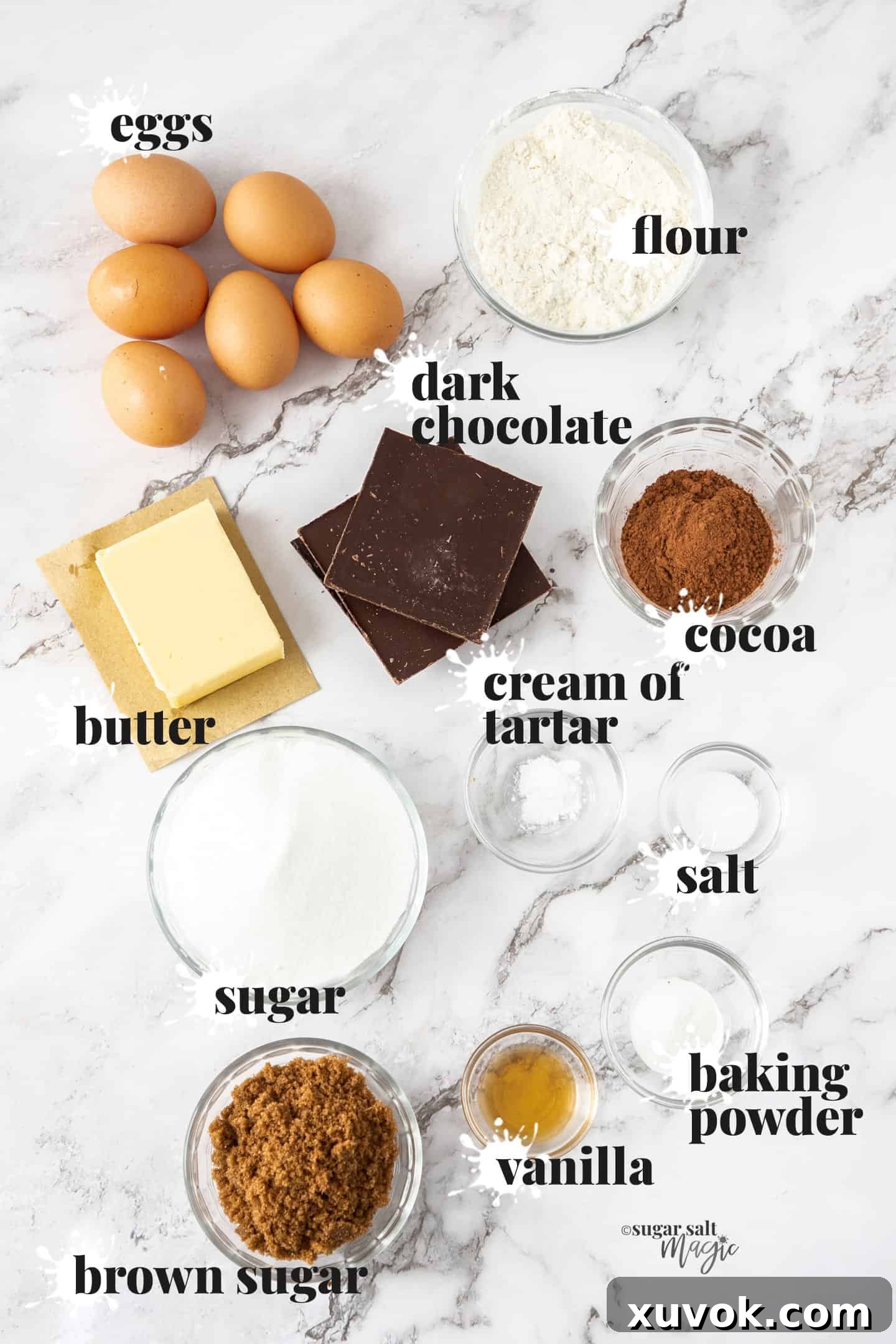 All the essential ingredients for making the Chocolate Meringue Brownie Cake neatly arranged on a pristine marble surface, ready for preparation.