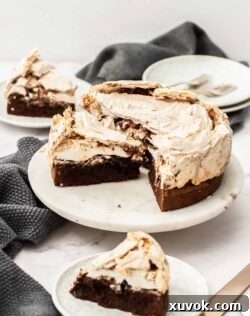 A meringue cake cut into perfect slices, beautifully arranged on a white marble cake platter, ready to be enjoyed.