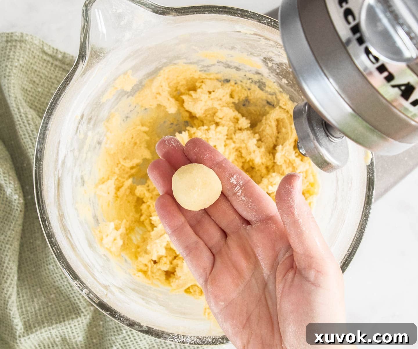 A perfectly rolled ball of yo yo biscuit dough held in an open hand.
