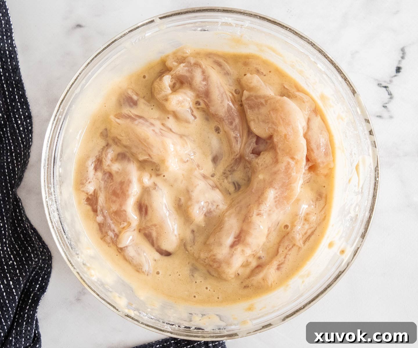 The tenderloins in a bowl mixed into the batter.