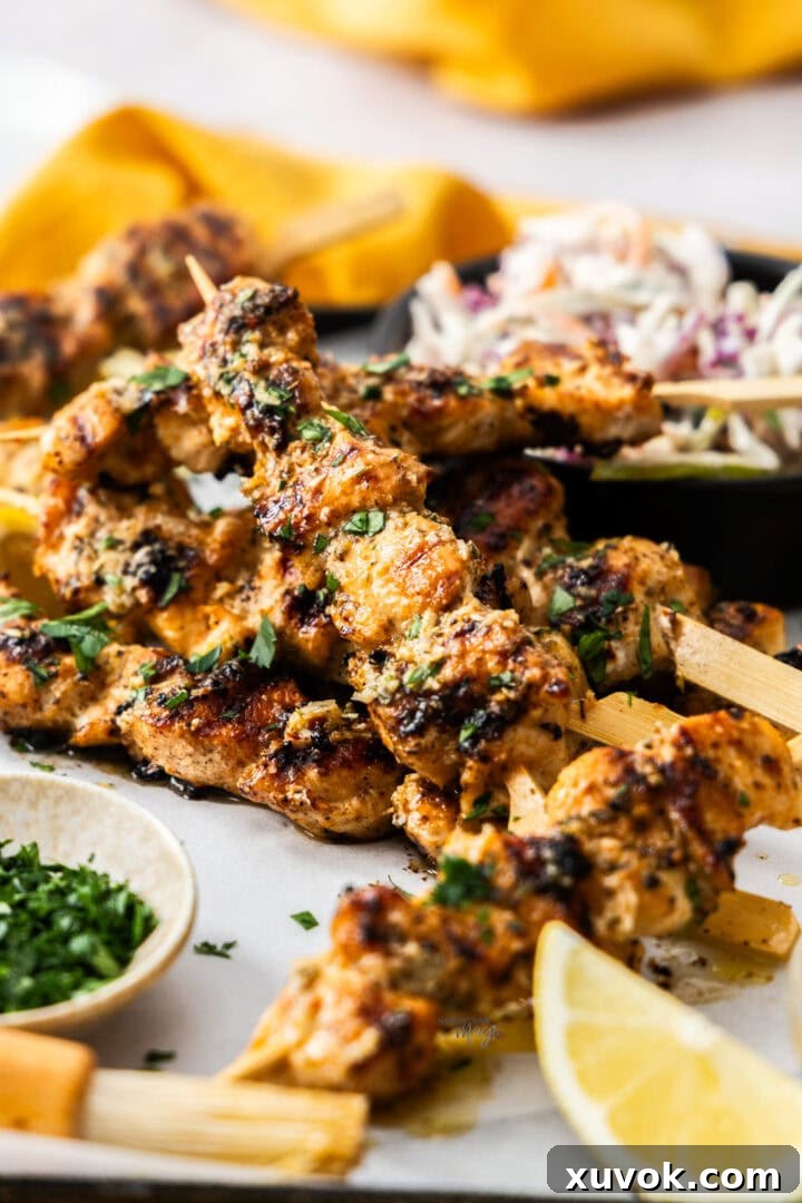 A pile of juicy garlic parmesan chicken skewers, garnished with fresh parsley.