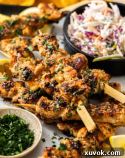 A pile of garlic parmesan chicken skewers on a tray, ready to be served.