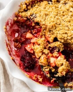 A close-up shot of the cooked fruit filling within the apple and blackberry crumble, showing the juicy texture.