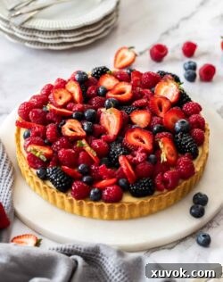 A tart filled with custard and topped with fresh berries.
