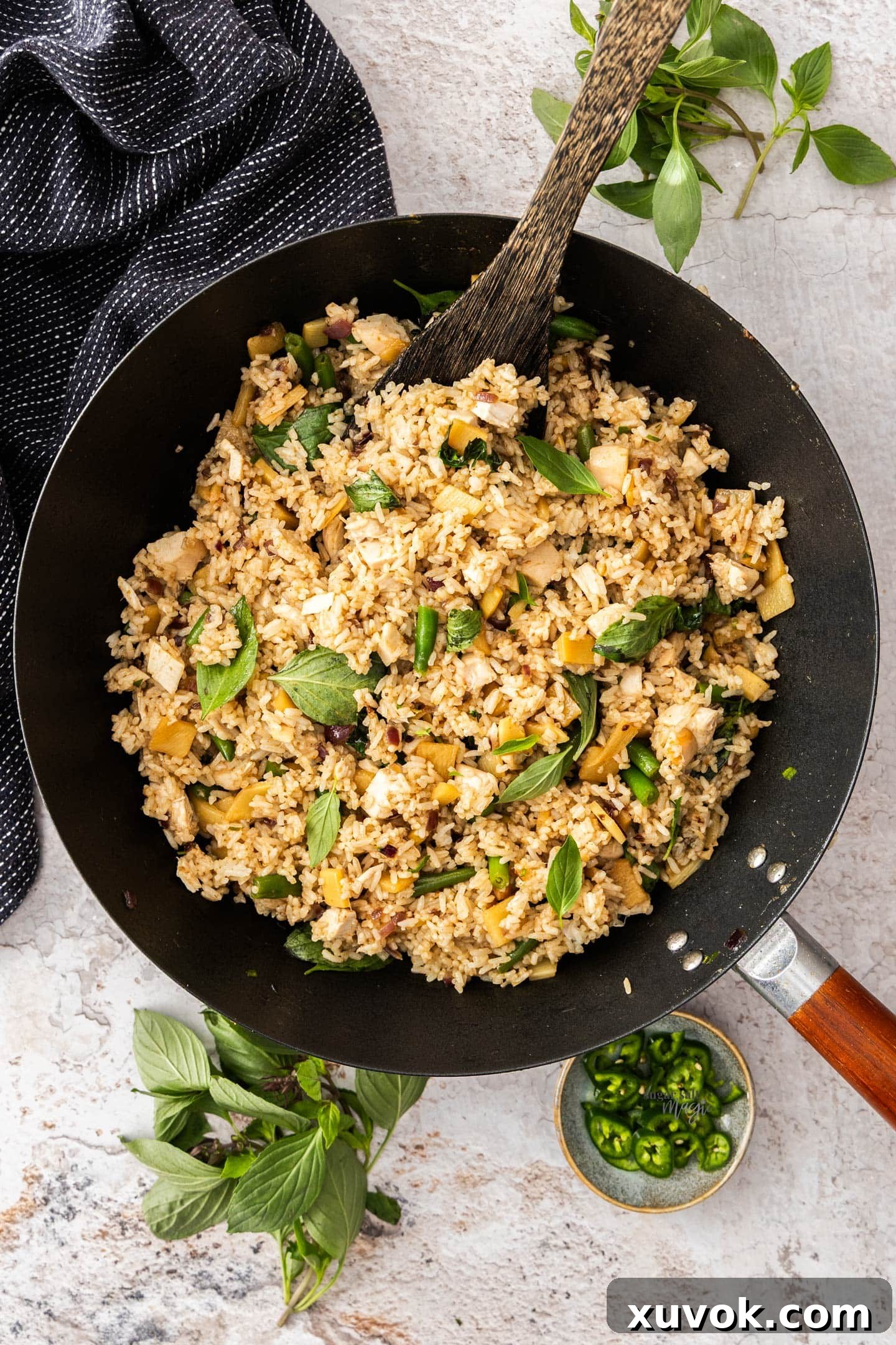 A stunning top-down view of vibrant Thai green curry fried rice with chicken, beautifully presented in a large wok, garnished and ready for serving.