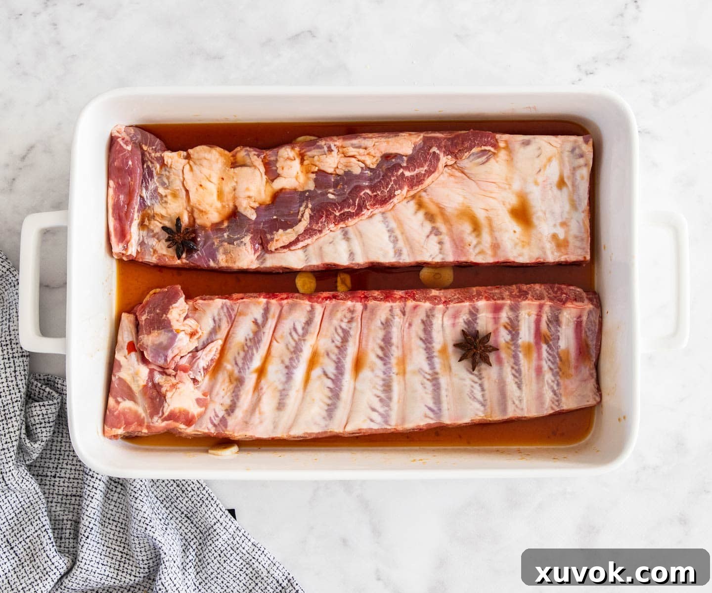 The sticky asian pork ribs arranged in a baking dish, ready to go into the oven.