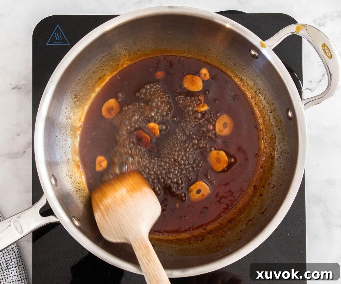 The Asian glaze simmering and reducing in a saucepan.