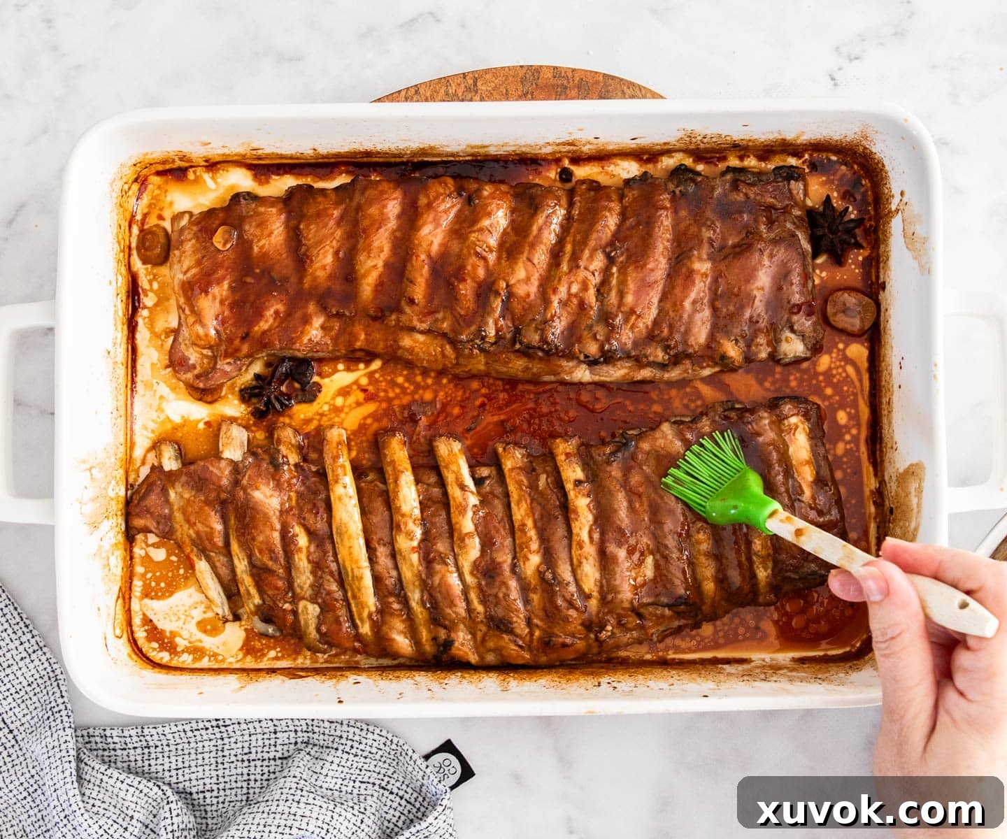 Brushing the sticky asian glaze over the oven-baked ribs.