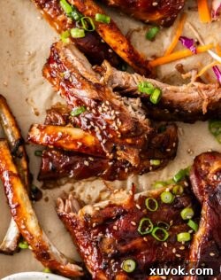 Top down view of the torn apart pork ribs after baking, on a baking tray.