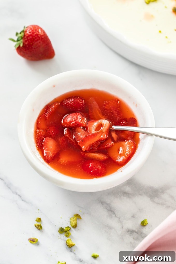 A white bowl filled with glistening macerated strawberries, ready to be served.