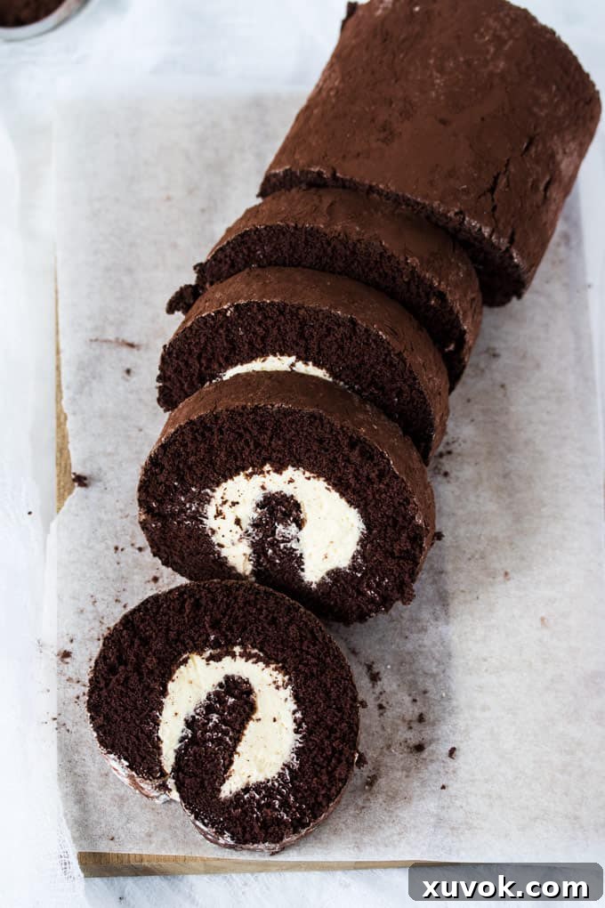 A chocolate roll cake dusted with cocoa on a wooden board, ready to be served.