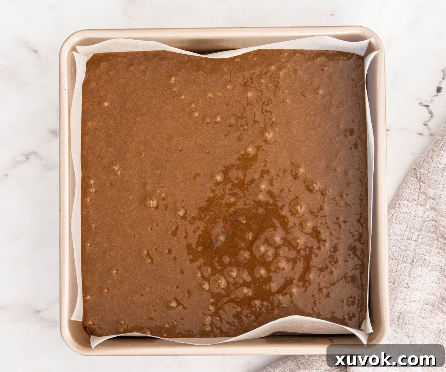 The gingerbread blondie batter in a square baking pan.