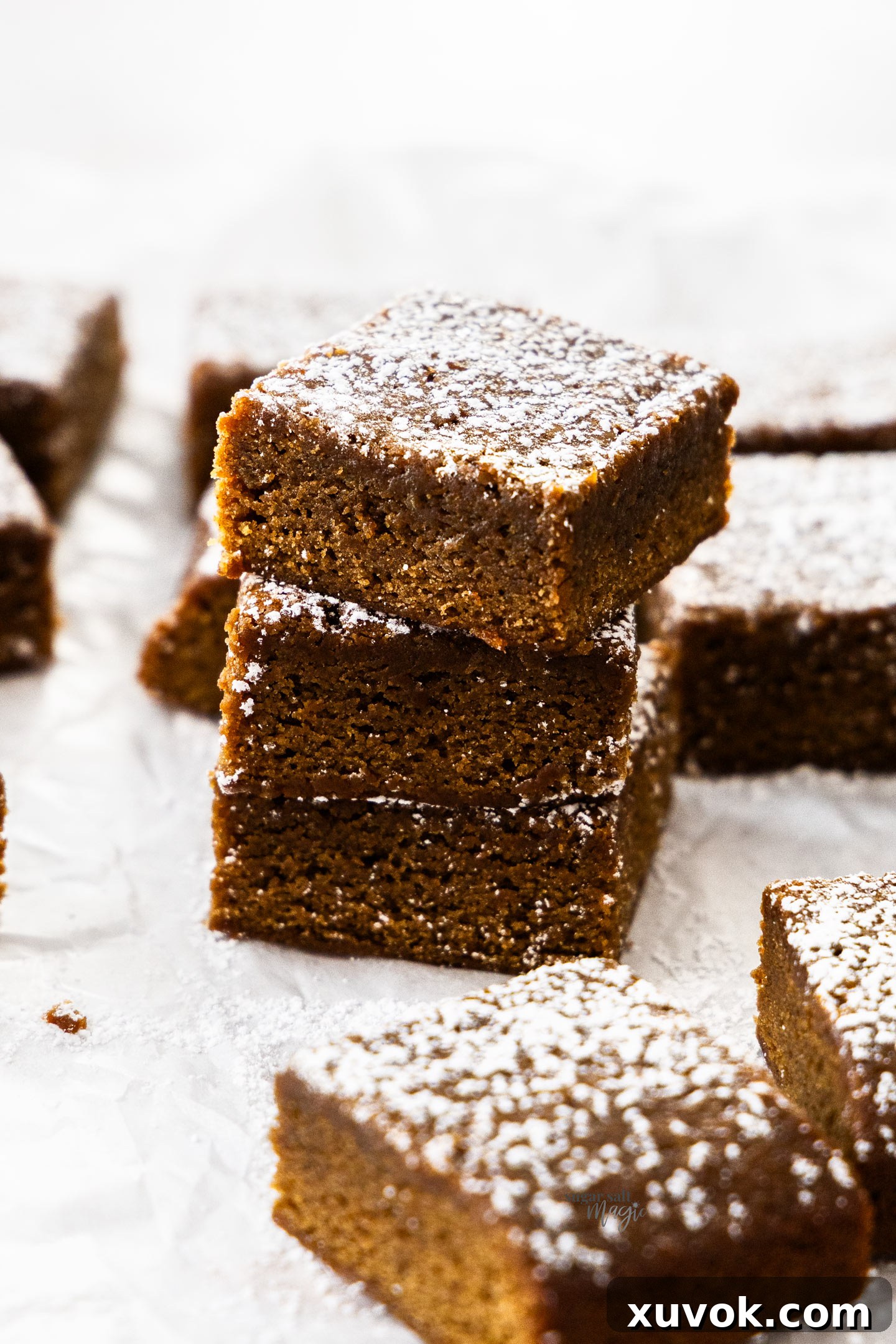 A stack of 3 gingerbread blondies with more surrounding them.