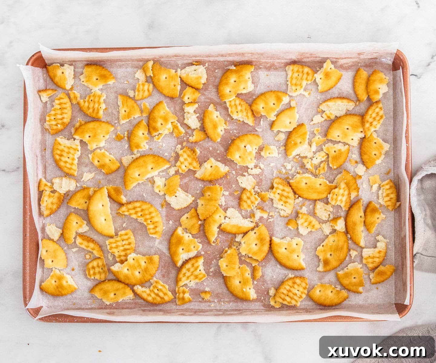 The ritz crackers broken up and evenly spread in a baking tray, forming the base of the florentine slice.