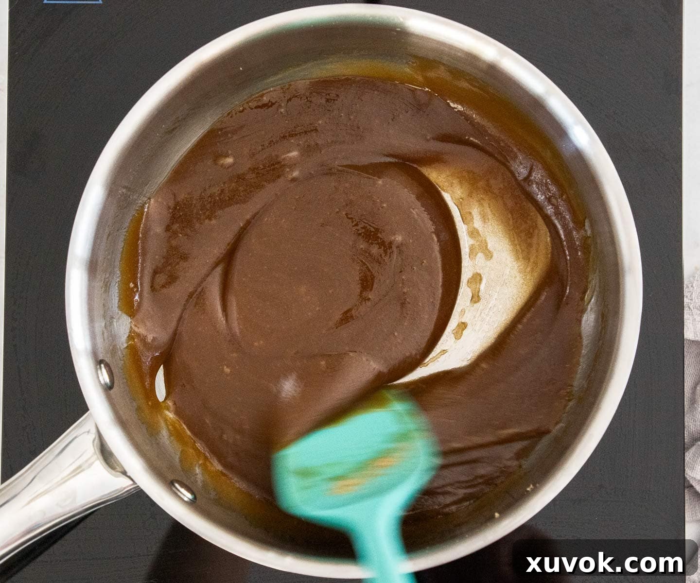 The sugar and butter stirred together in a pan over medium heat, beginning to melt and combine for the toffee mixture.