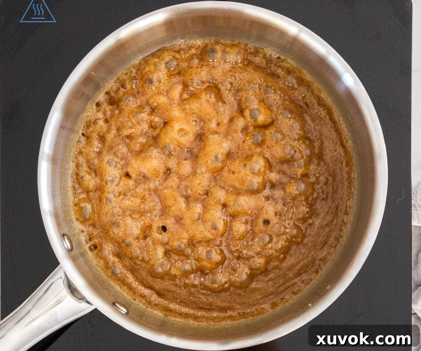 The toffee mixture bubbling gently in a pan after simmering for 2 minutes, indicating it's ready for the next step.
