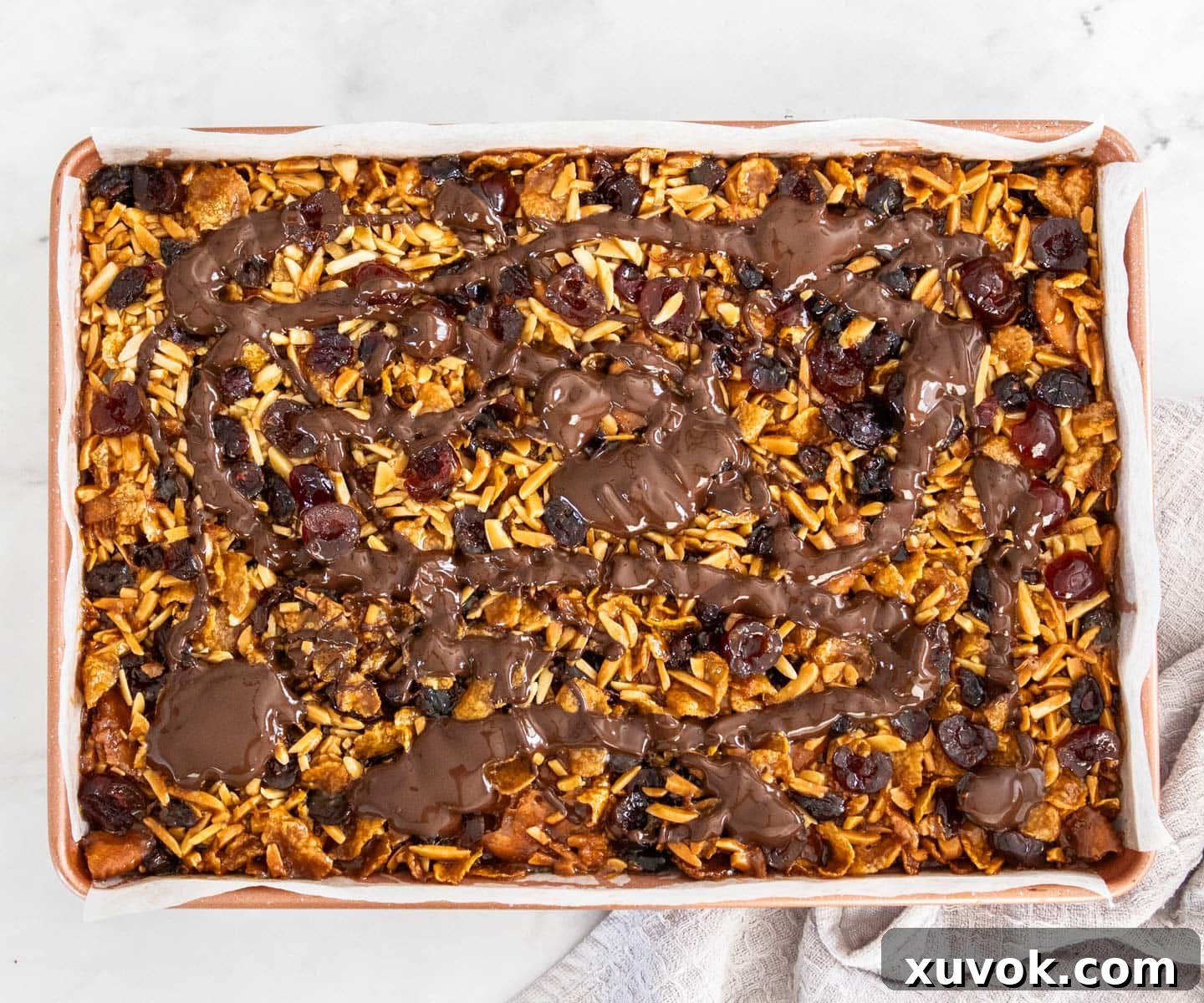 Melted dark chocolate drizzled artistically over the cooled Florentine slice, adding the final touch.