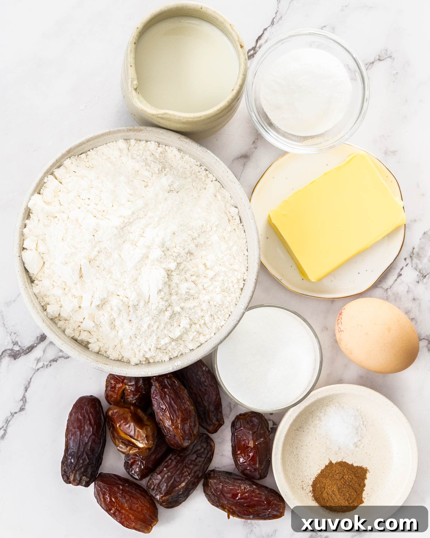 Ingredients for date scones neatly arranged on a pristine marble background.