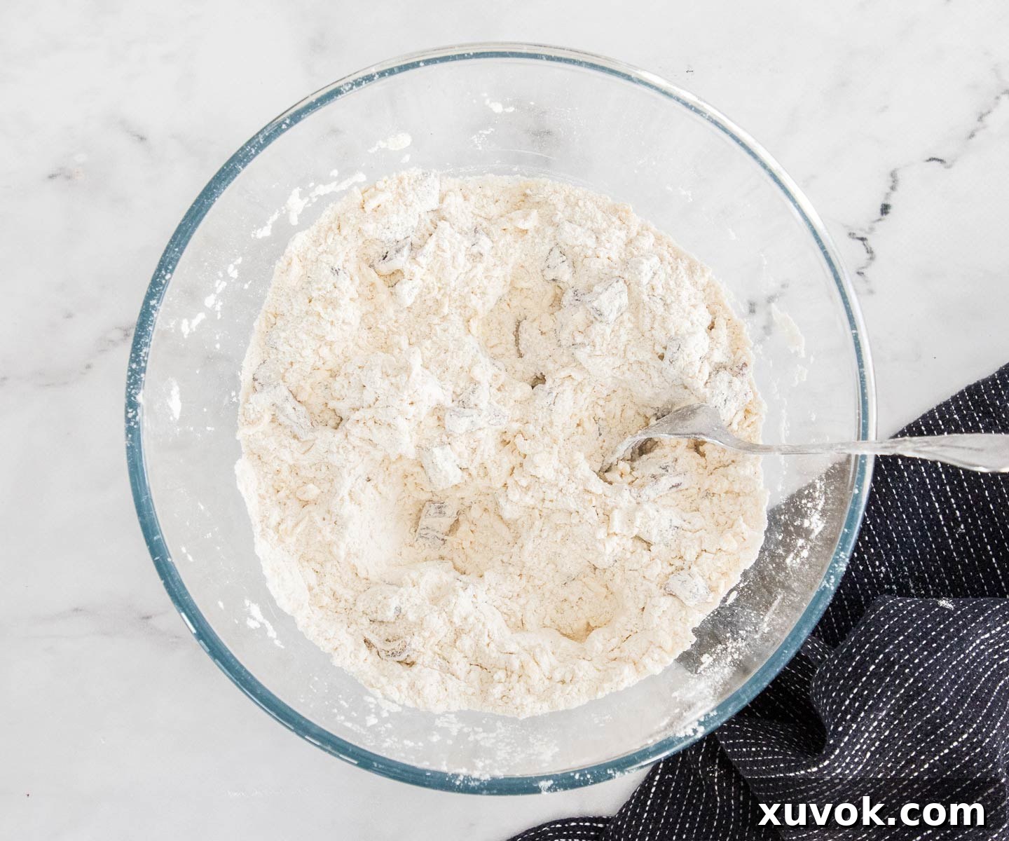 The chopped dates mixed into the dry ingredients and butter in a bowl.