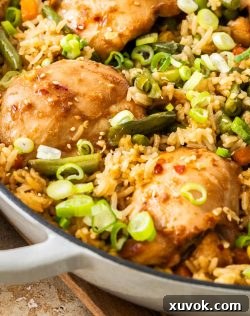 Closeup of the cooked chicken thighs nestled into rice and veggies.