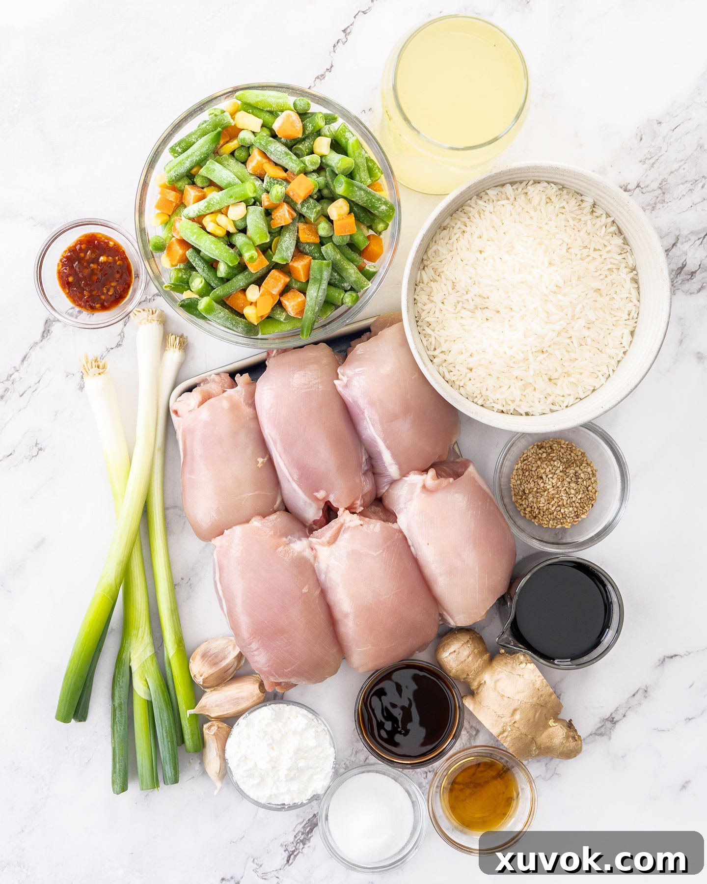 Ingredients for chicken and rice bake on a marble surface.