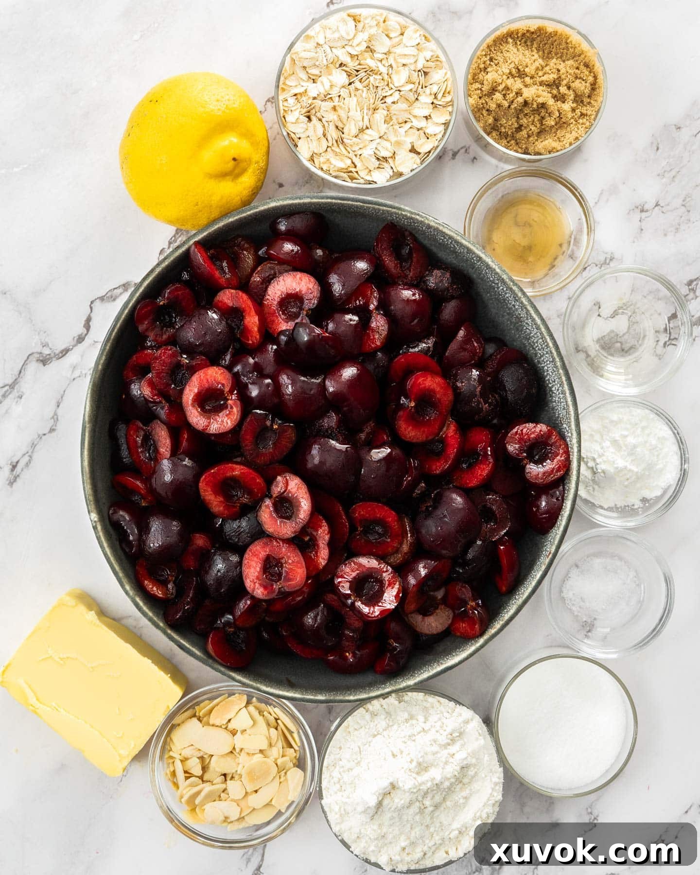 Top down view of cherry crumble ingredients on a marble surface.