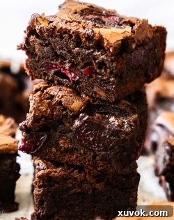 A stack of 3 rich, fudgy cherry brownies, showcasing their decadent texture.