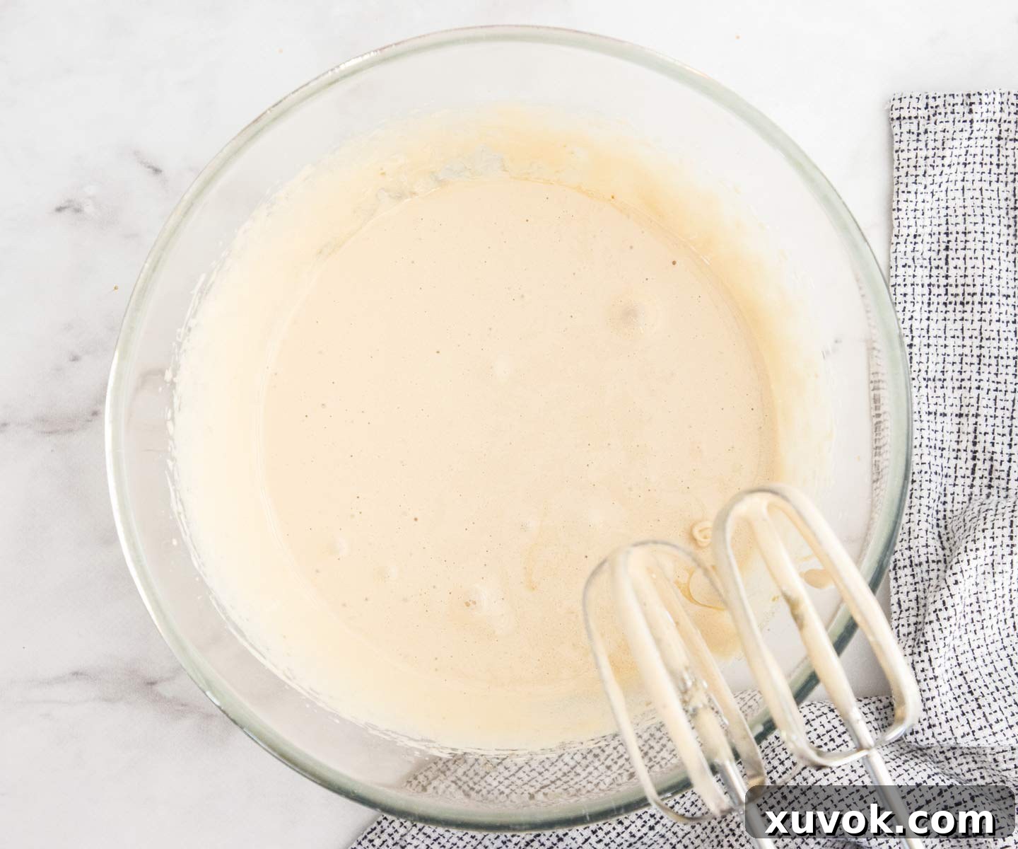 The eggs and sugar beaten together to a thick, pale, and fluffy consistency, key for a crackly brownie top.