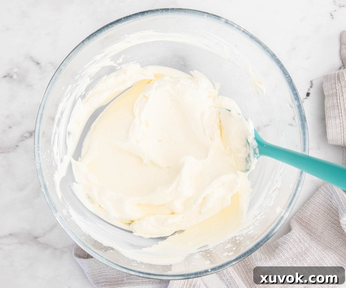 Heavy whipping cream, sugar, and vanilla extract whipped to firm peaks in a mixing bowl.
