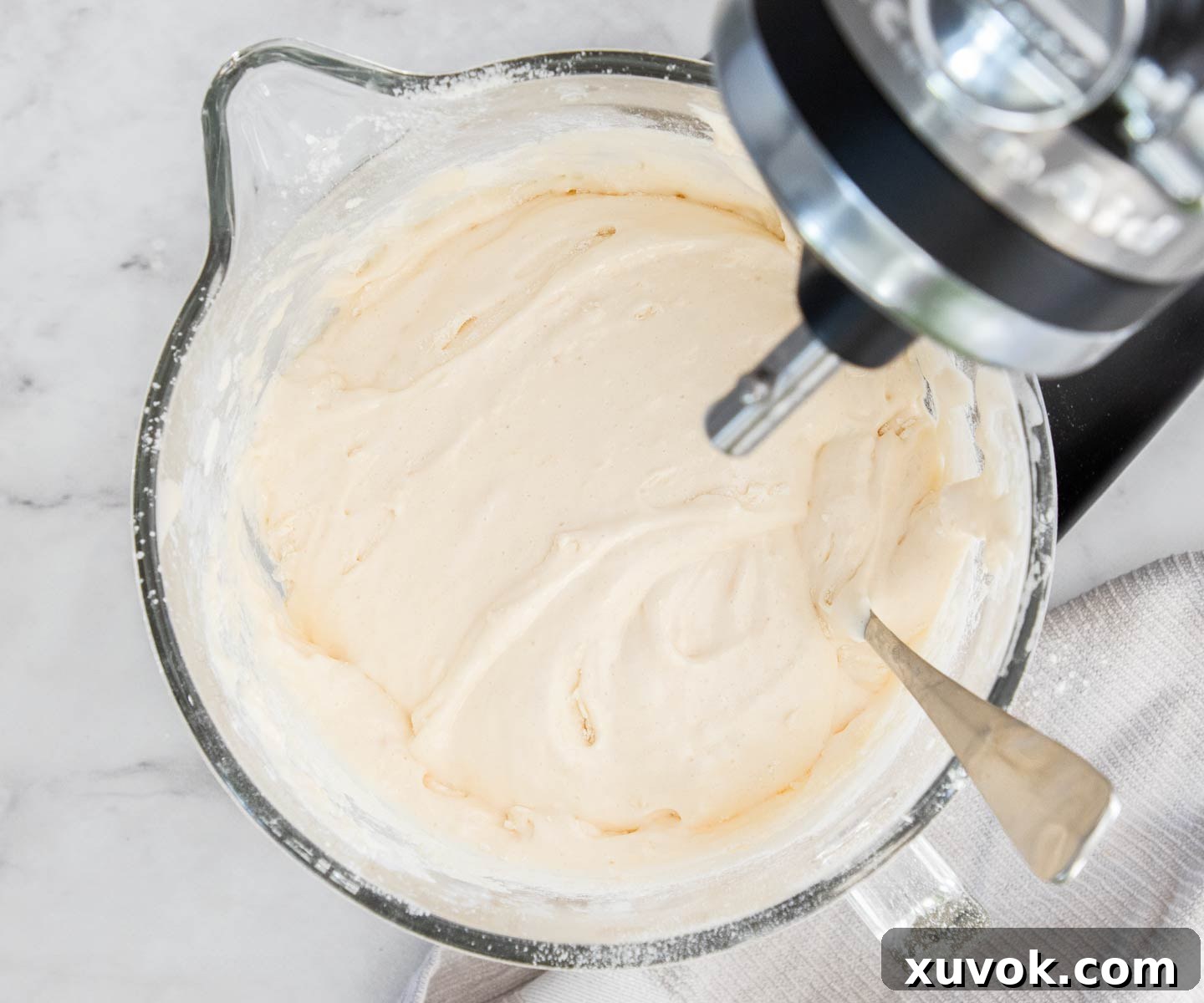Dry ingredients gently folded into the frothy egg and sugar mixture using a metal spoon.