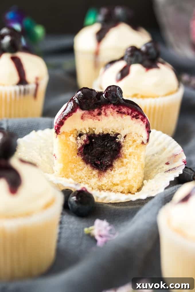 A Lemon Blueberry Cupcake cut in half showing a luscious blueberry compote center.