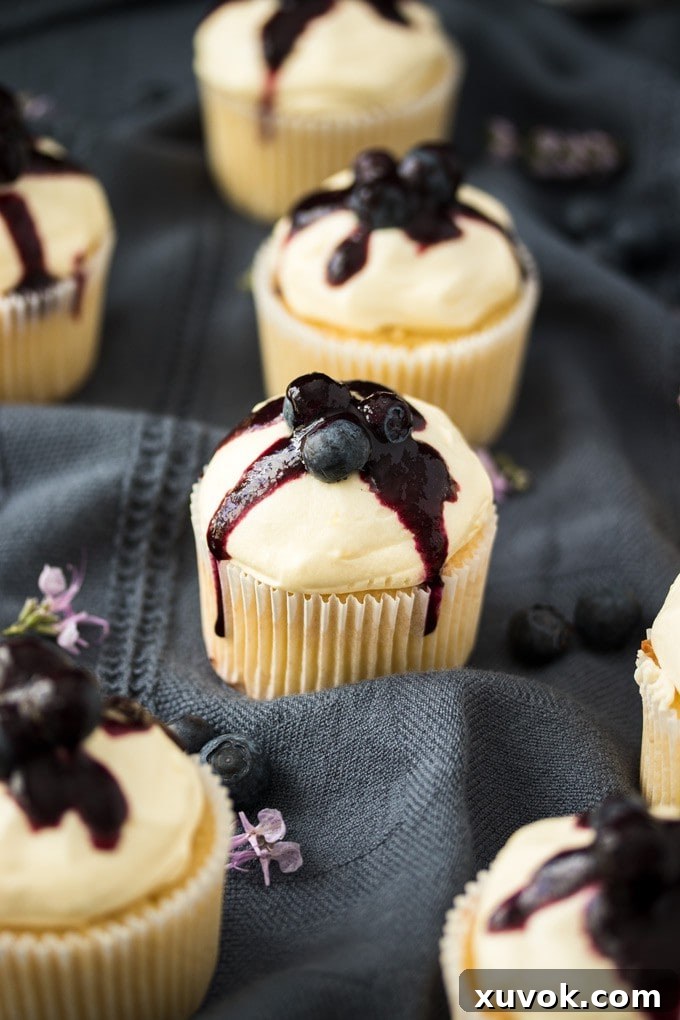 Lemon Blueberry Cupcakes elegantly arranged on a blue-gray tea towel.