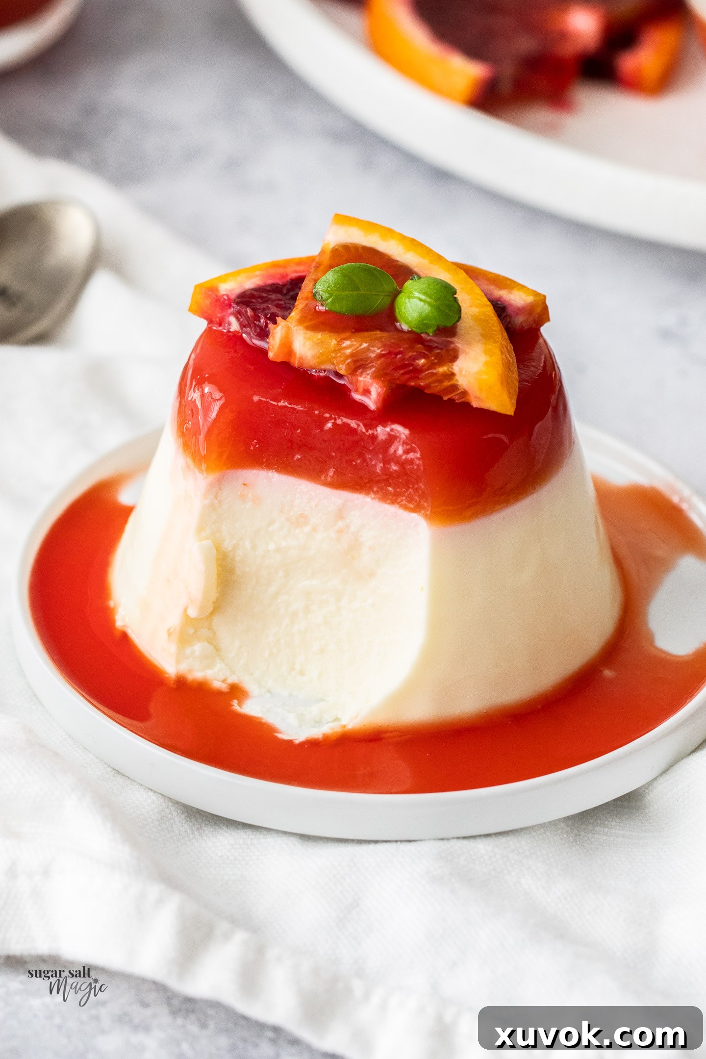 A panna cotta with a spoonful taken out of it.