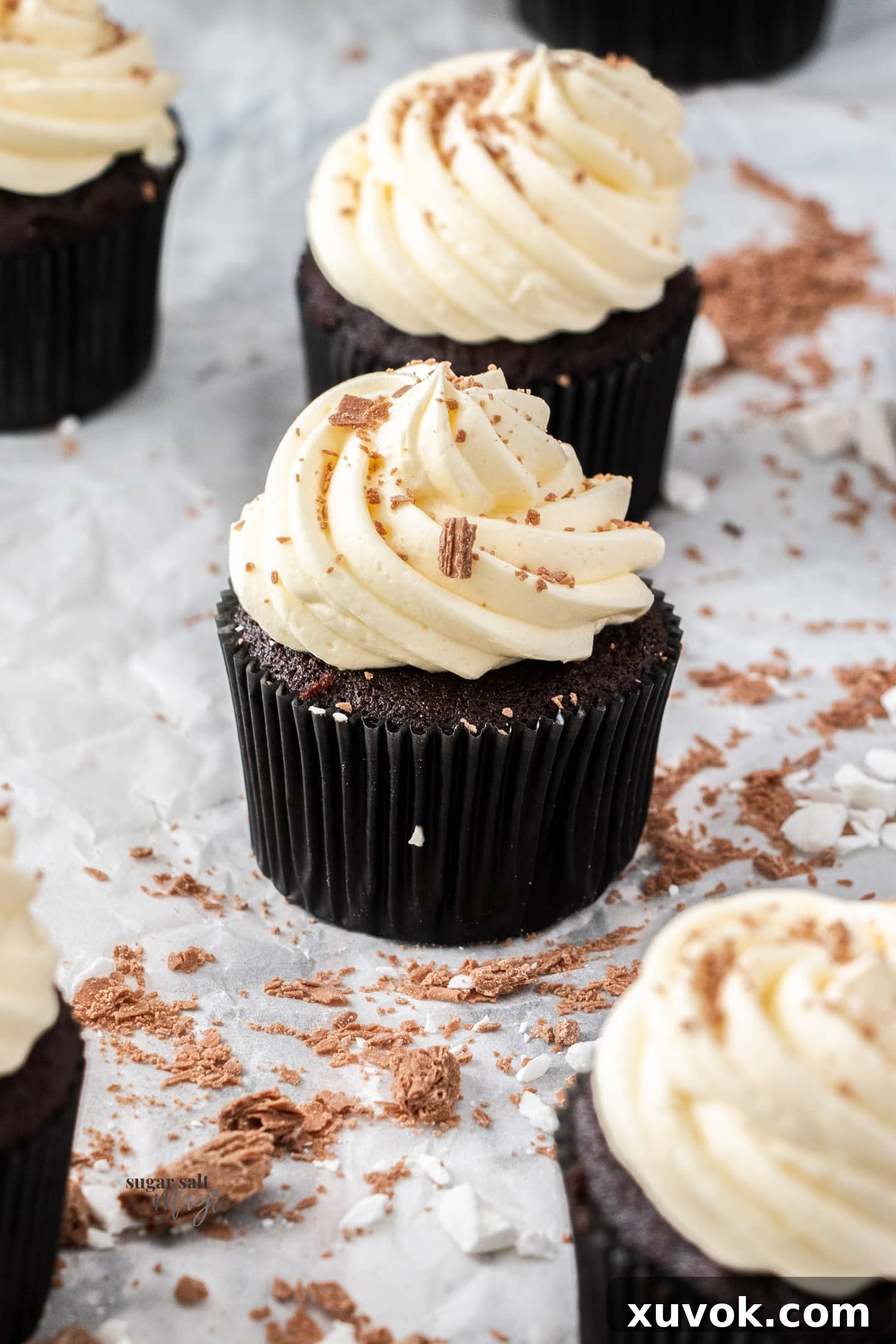 A perfectly baked chocolate mint cupcake, topped with a delicate swirl of vibrant green peppermint buttercream, showcasing its rich chocolate base and creamy frosting.