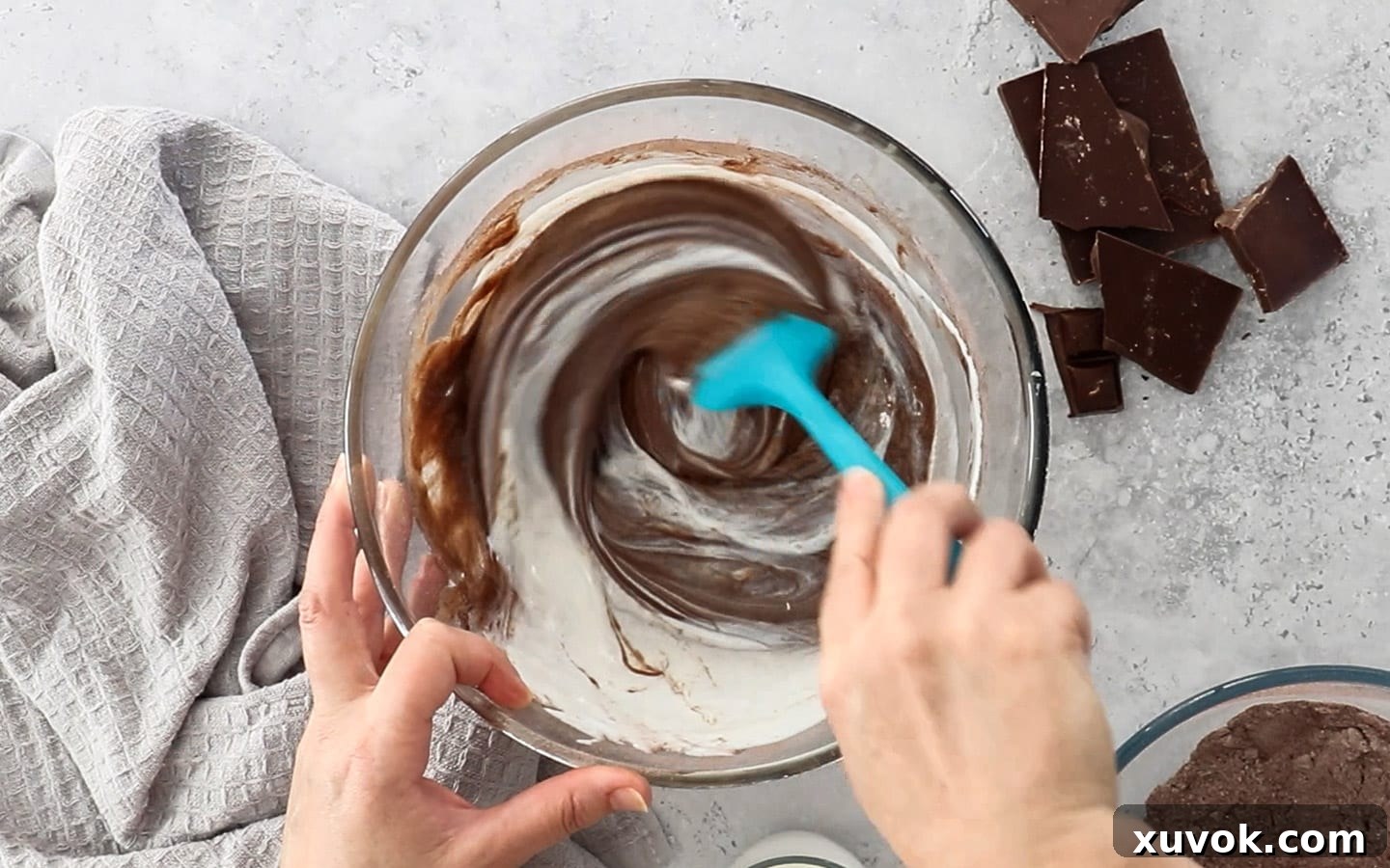 Mixing buttermilk into the chocolate cupcake batter, creating a smooth and consistent consistency.