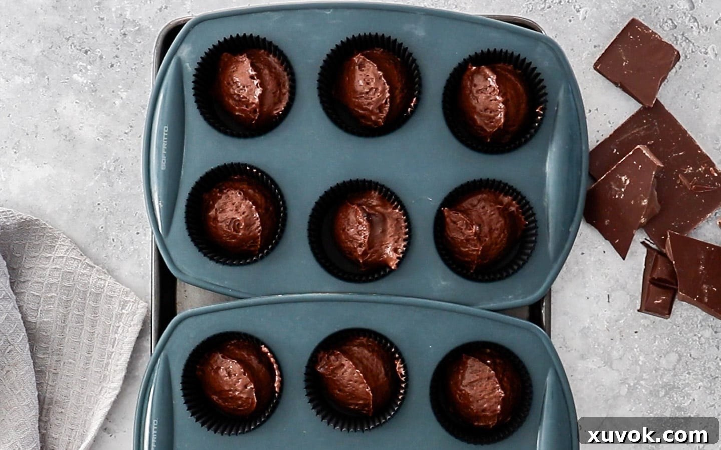 The chocolate cupcake batter evenly portioned into muffin pan liners, ready for baking.